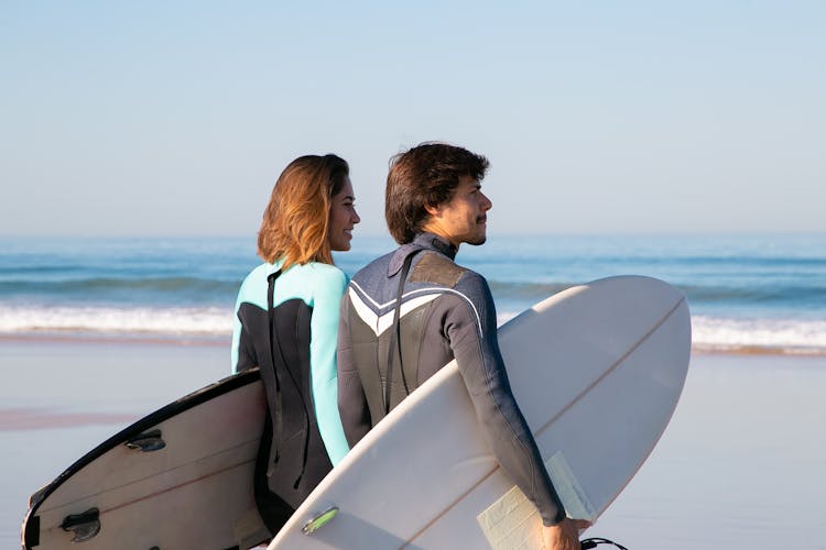 Couple Carrying Surfboards