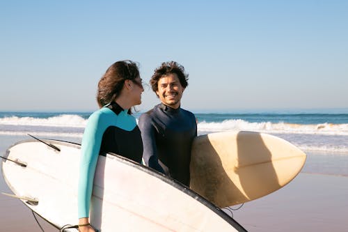 Couple Carrying Surfboards