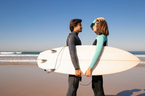 A Surfer Couple Standing Face to Face