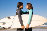 A Happy Surfer Couple Smiling at Each Other
