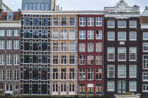 Free Colorful historic canal houses in Amsterdam showcasing unique Dutch architecture. Stock Photo