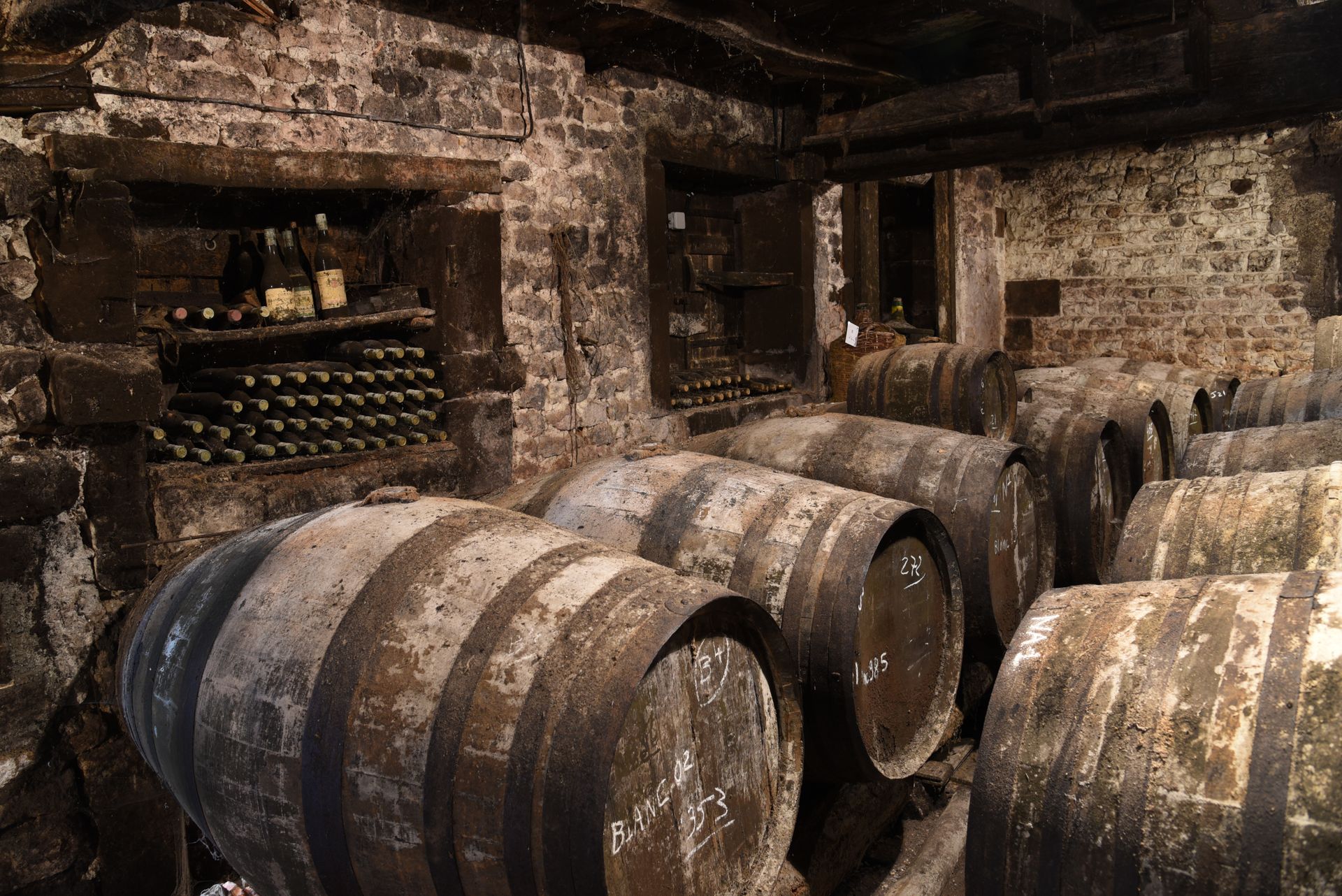A stone chai in Gascony, oak casks chalked with their year