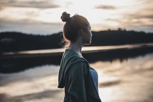 Free A Side View of a Woman Standing Near the Lake Stock Photo