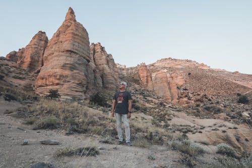 An Elderly Man Standing Near the Rock Formations