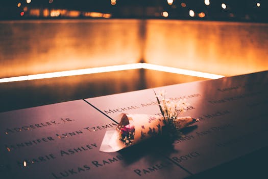 A bouquet on engraved names at the illuminated 9/11 Memorial in NYC.