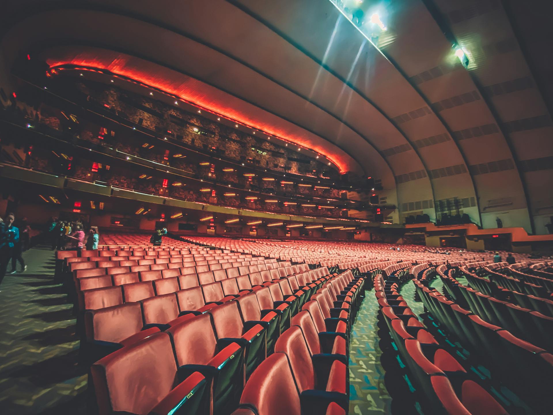 Expansive interior of a modern theater with rows of empty seats and warm lighting creating an inviting atmosphere.