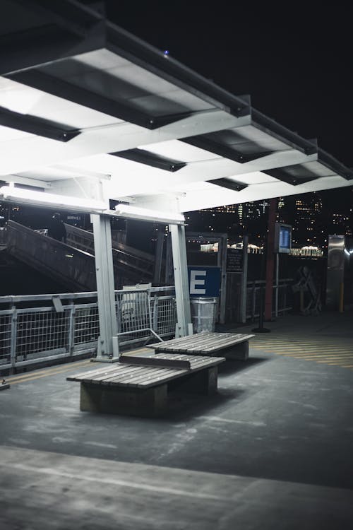 Empty Illuminated Train Station Platform in City at Night 