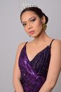 A Woman in Purple Dress Looking while Wearing a Tiara