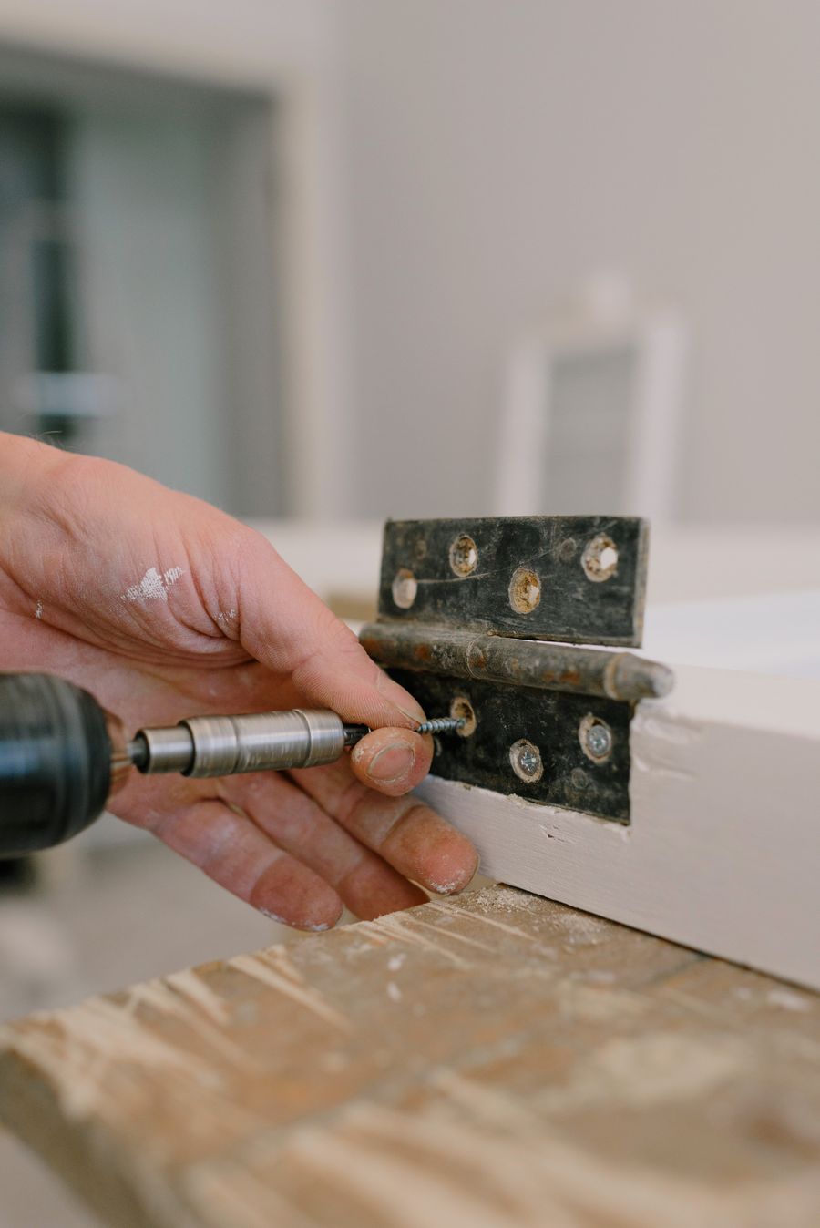 Handyman repairing a door hinge