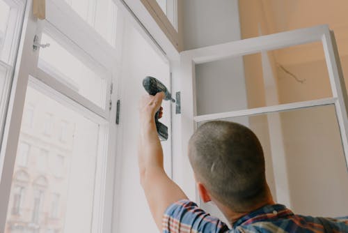Free Anonymous man installing window in room Stock Photo
