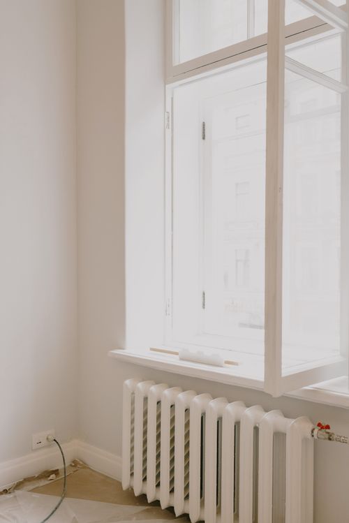 Free Interior of light room with open white window with instruments on windowsill over battery in apartment with white wall during repair works Stock Photo