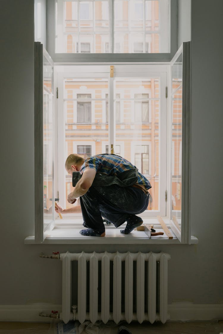 Anonymous Man On Windowsill During Repair Work