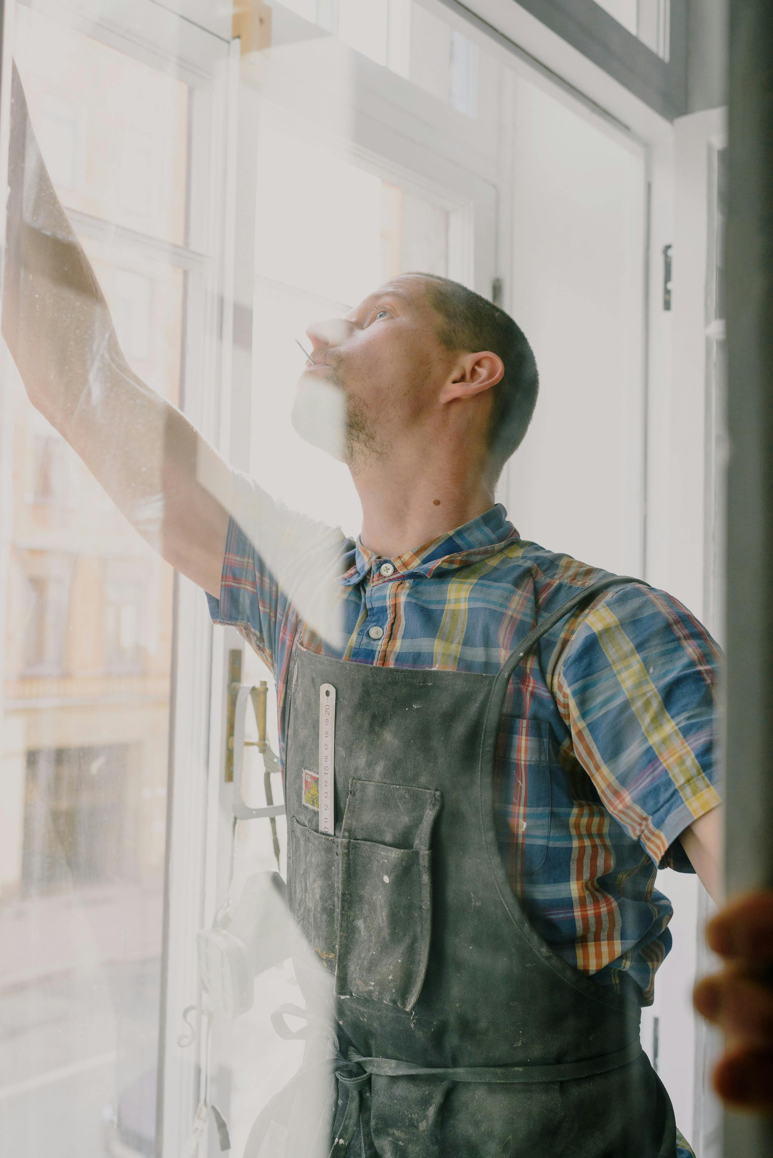 man installing window in room