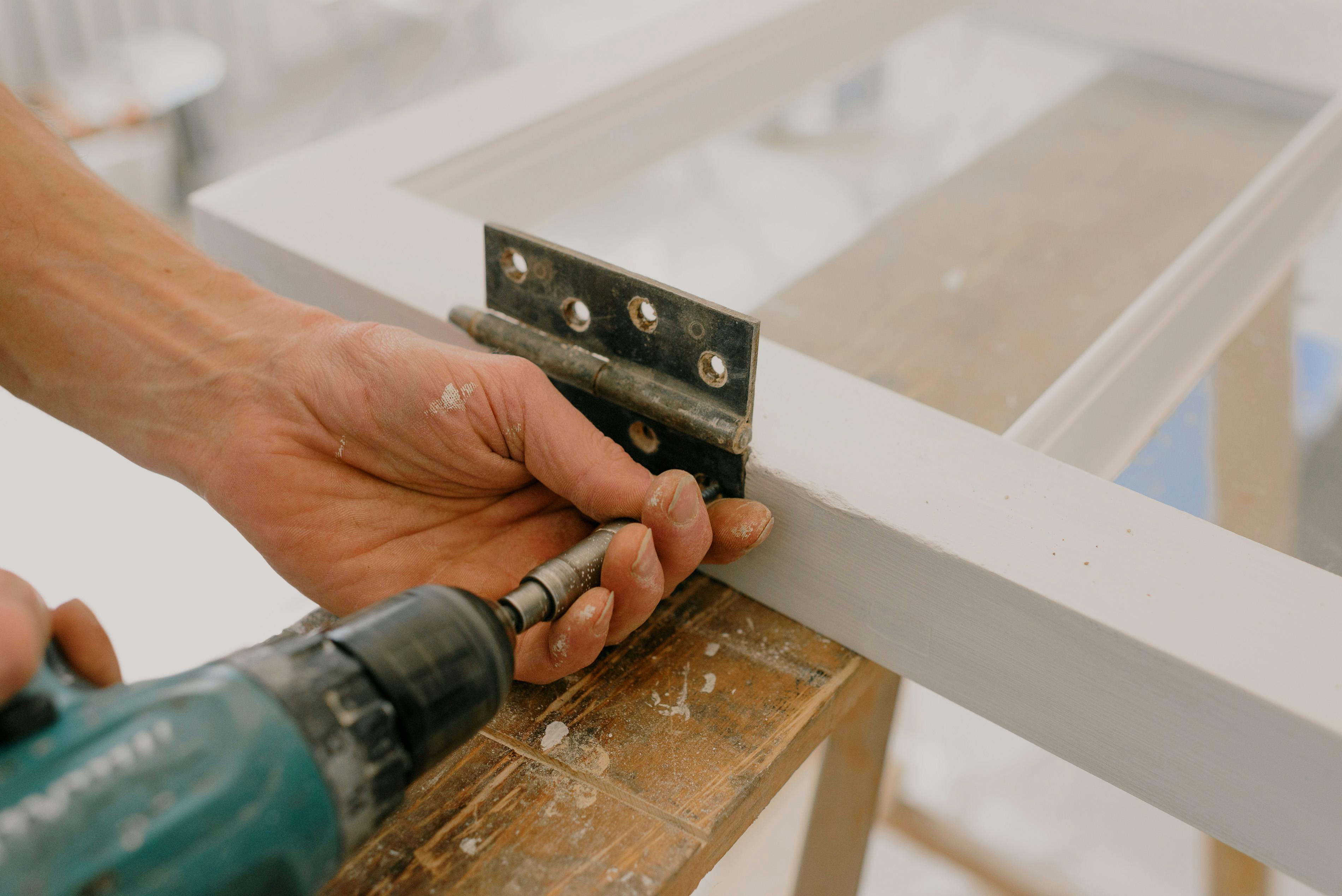 crop workman drilling hinge on window frame