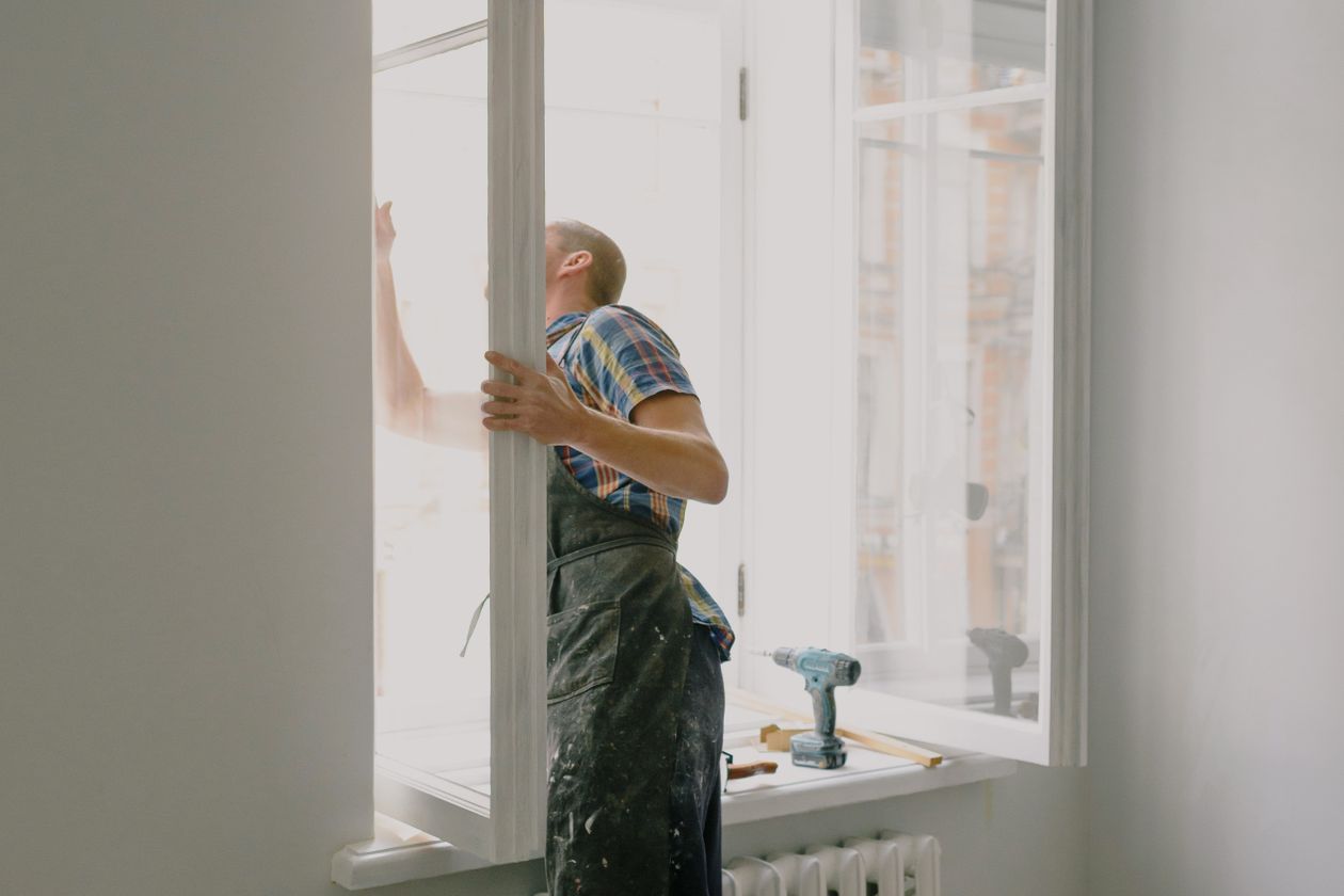 Worker installing a new window in a bright home interior