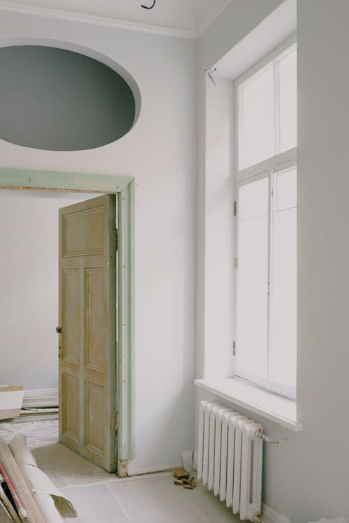 Contemporary apartment interior with shiny window and door near construction materials on floor in daytime