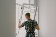 Unrecognizable workman installing window in house during renovation process