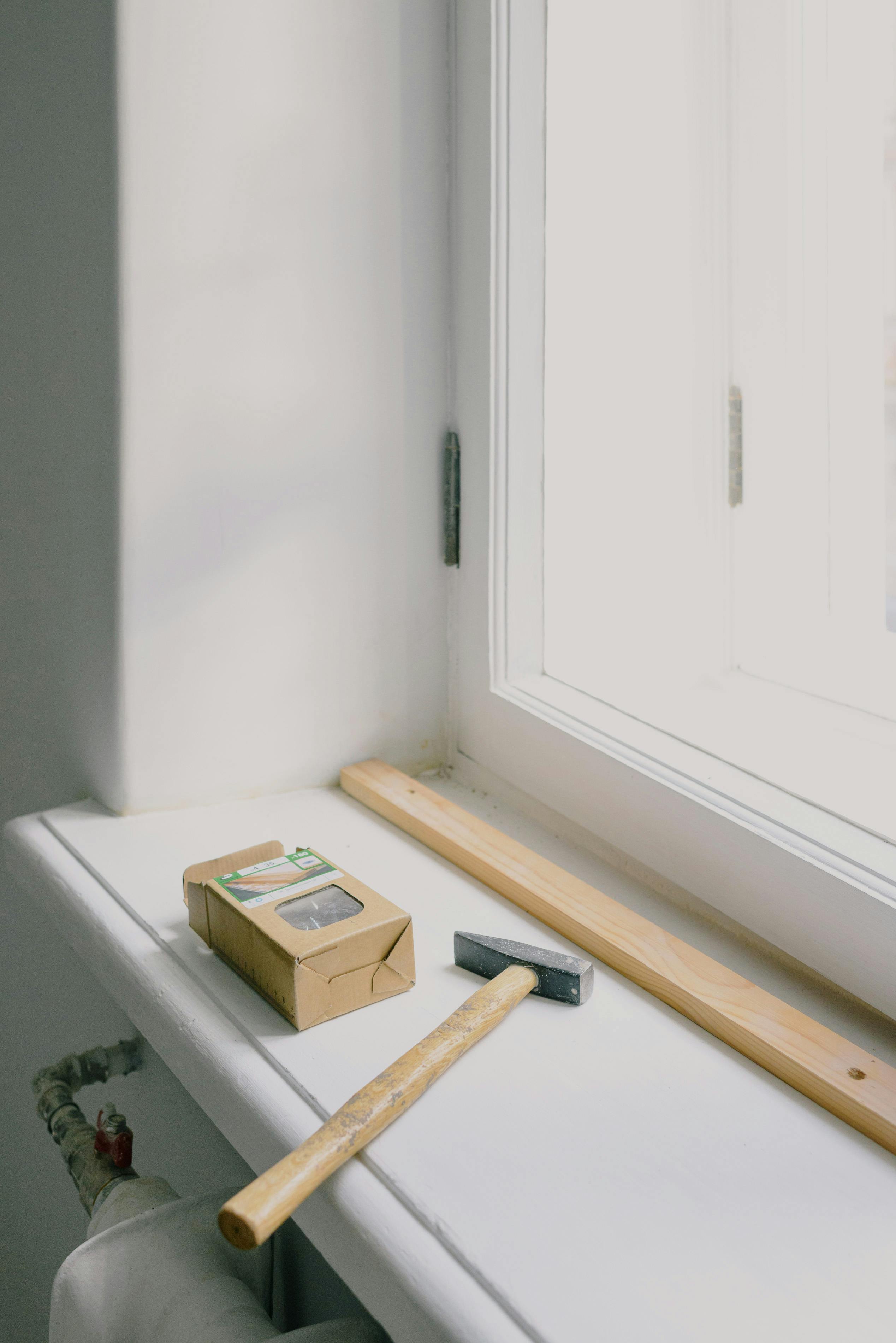 hammer near paper box on windowsill at home