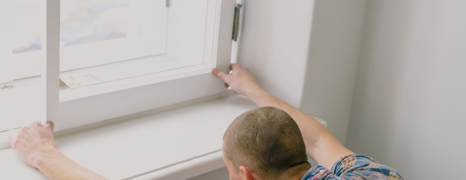 Fitter installing a new window indoors