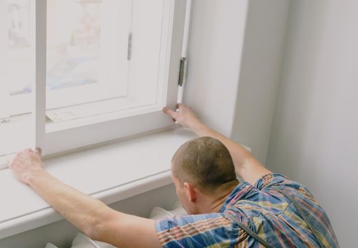 Fitter installing a new window indoors