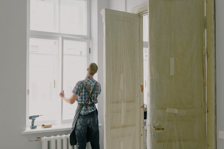 Faceless Handyman Installing Window In New House