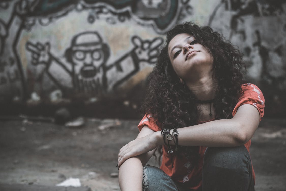 Free Woman Sitting Near Gray Wall Stock Photo