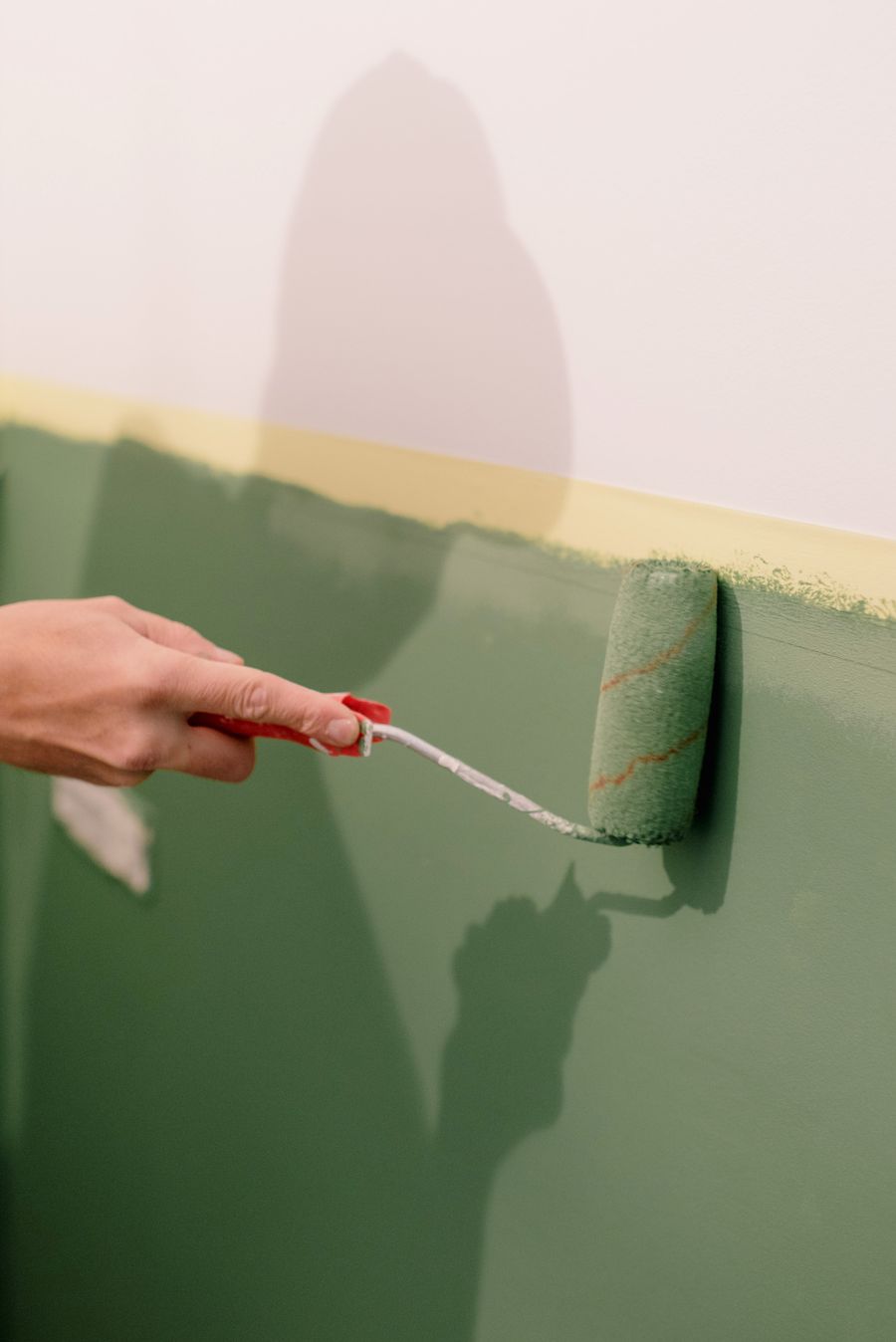 Painter using a roller to paint an interior wall