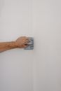 Crop man flattening wall at home