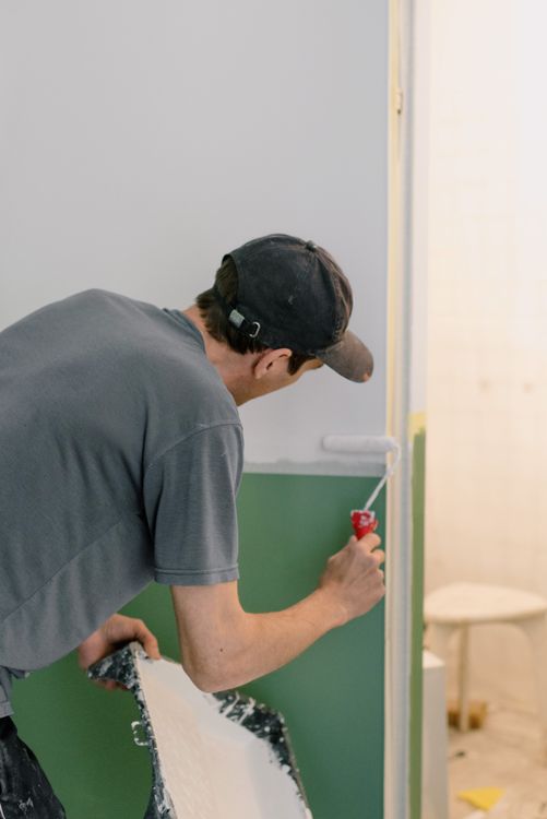Professional painter decorator painting interior walls of a London residential property