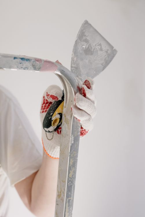 Professional handyman repairing drywall with tools