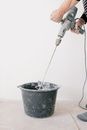 Crop man mixing cement in room