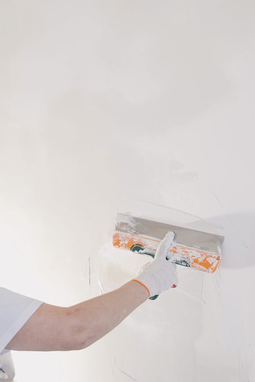 Free Crop man plastering wall at home Stock Photo