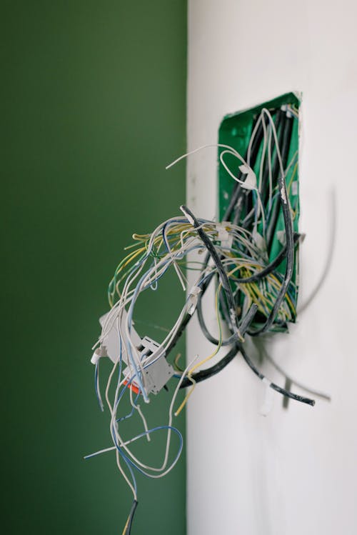 Free Opened power socket with various wires on white wall during repair at home Stock Photo