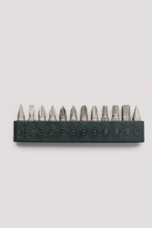 Top view of professional metal tool bits for screwdriver in case on white table
