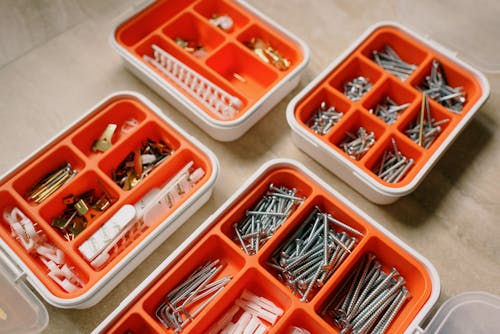 Free From above of boxes with different metal nails and plastic dowels in workshop Stock Photo