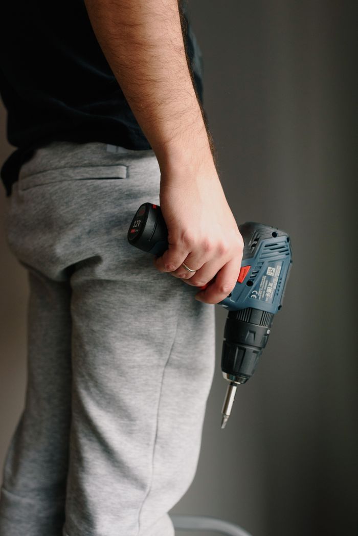 Handyman with cordless drill assembling