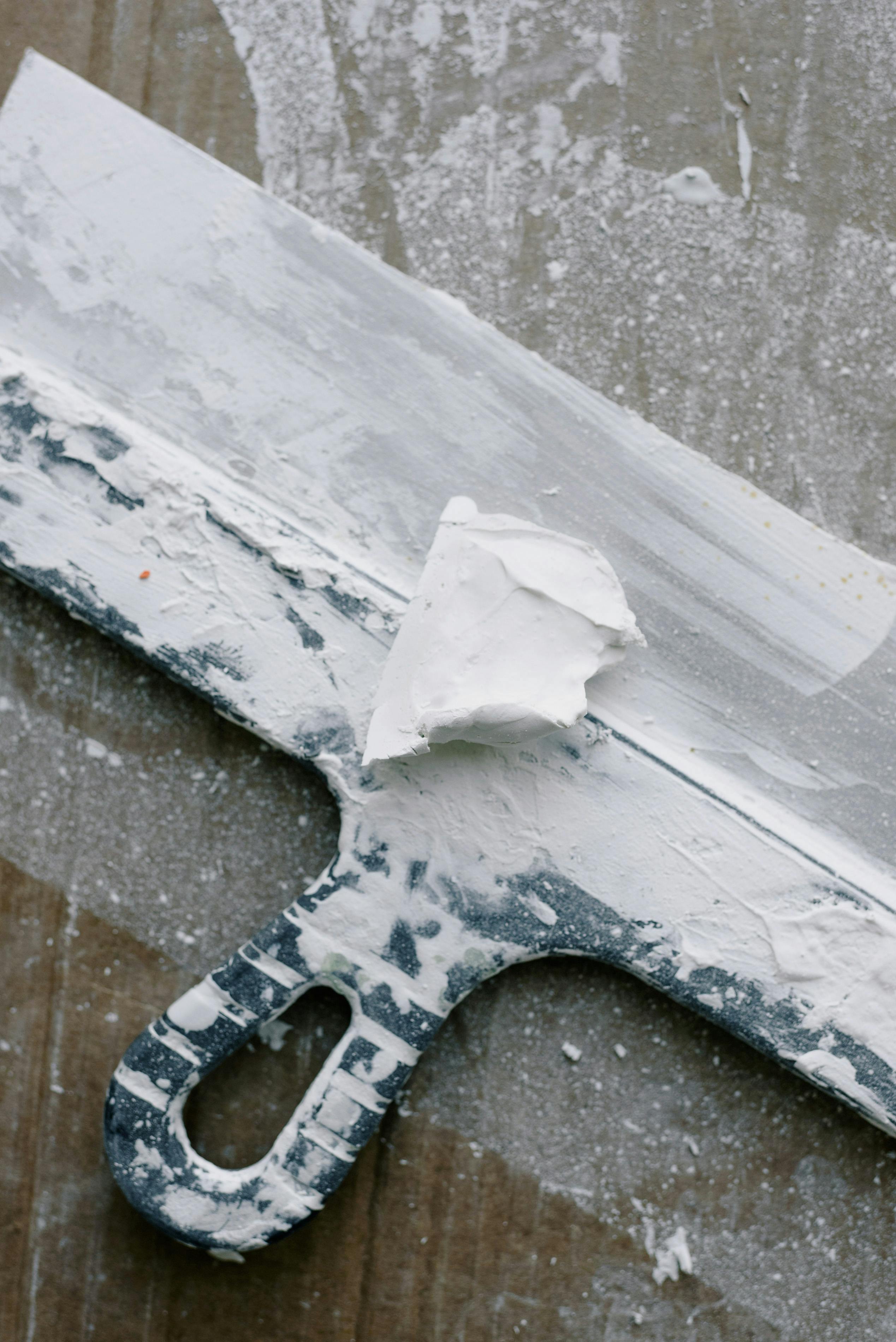 dirty spatula in plaster on table