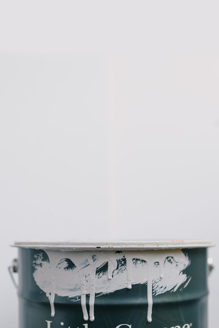 Metal Bucket In Paint Against White Background