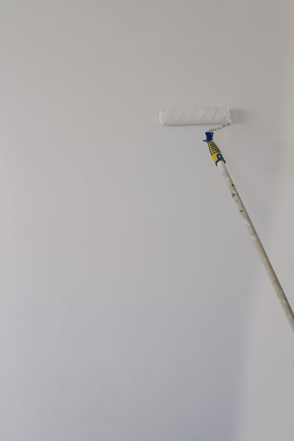 Paint roller applying a fresh coat to an interior wall