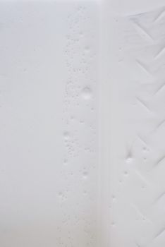 白色纹理石膏墙的特写镜头，上面有气泡和独特的图案