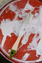 Brush in white paint placed on bottle lid
