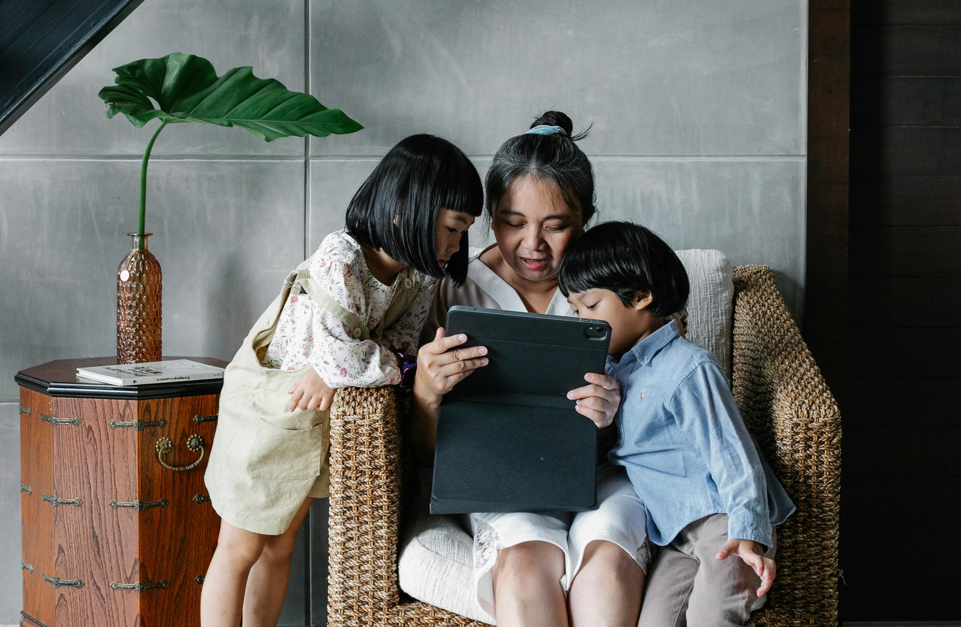 mother with children using tablet together