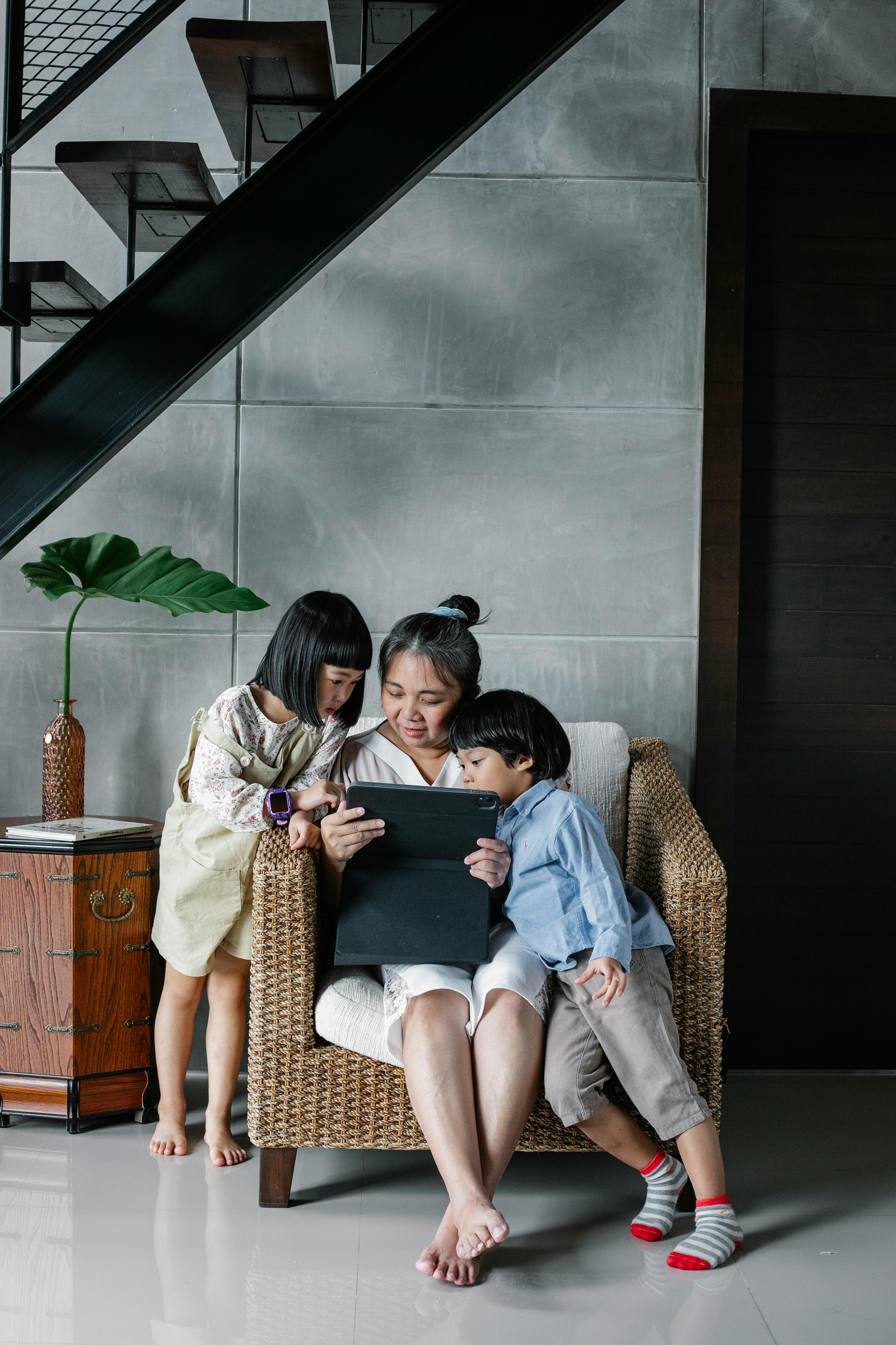 focused mother sitting with children at home