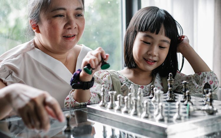 Asian Mother Playing Chess With Girl