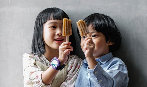 아이스크림을 보여주는 작은 아시아 아이