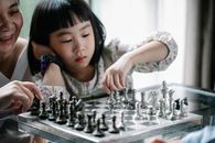 体贴的亚洲女孩白天在家陪保姆下国际象棋