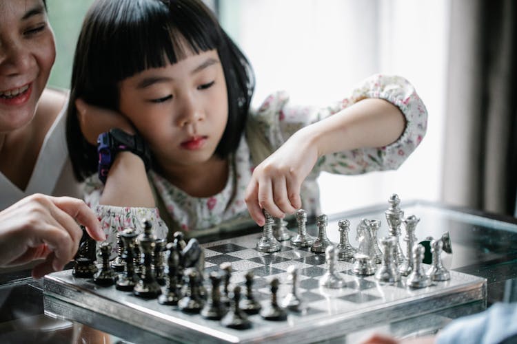 Pensive Asian Girl Playing Chess