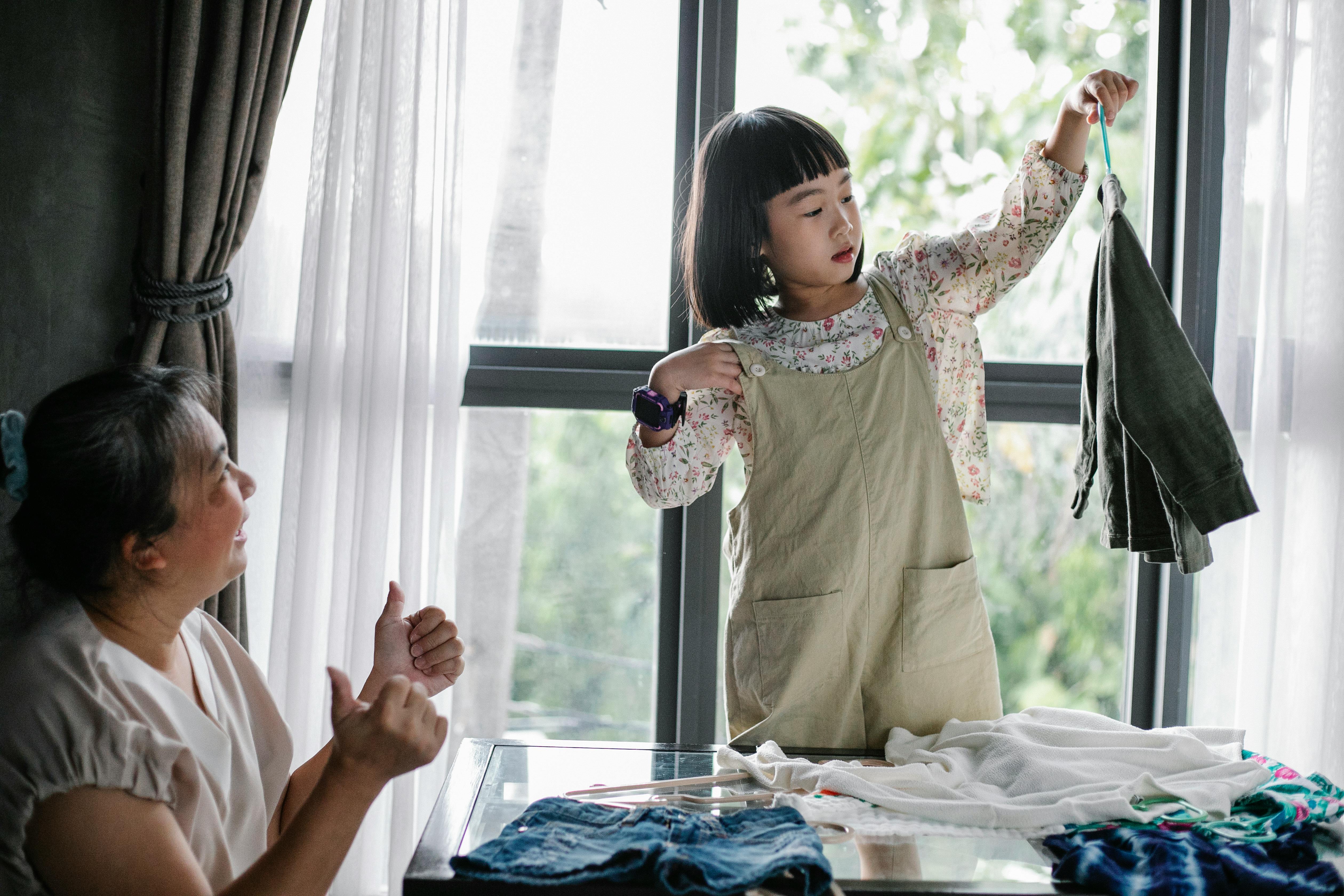 little girl organizing clothes with grandmother