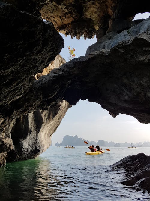 A Person Riding on a Kayak Near the Cave