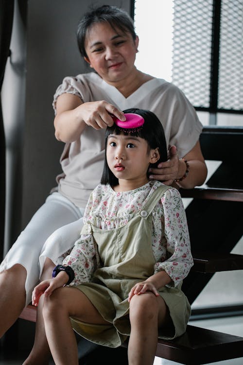 孫娘の髪型を作るアジアの女性